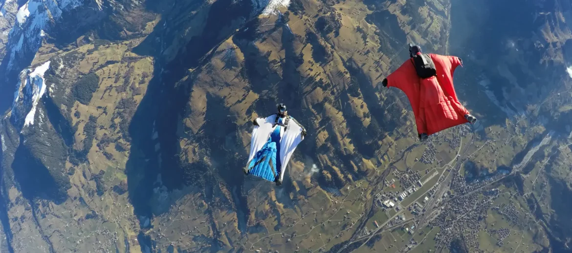 aerial-view-of-two-wingsuit-flyers-one-on-his-bac-2023-11-27-05-35-35-utc